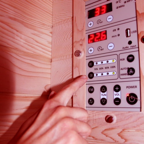 Hand adjusting a control panel with digital display on a wooden surface