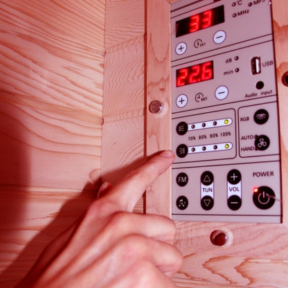 Hand adjusting a control panel with digital display on a wooden surface