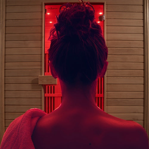 Person entering a wooden sauna with red interior light